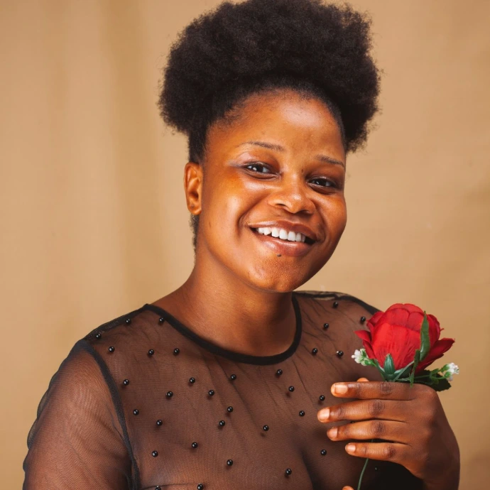 woman in gray tank top holding red rose